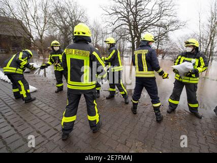 Lindheim, Deutschland. Januar 2021. Feuerwehrleute stapeln Sandsäcke, um Häuser vor der Überschwemmung des Nidder zu schützen. In der Wetterau haben zahlreiche Flüsse ihre Ufer durch den schmelzenden Schnee und die anhaltenden Niederschläge geplatzt. Quelle: Boris Roessler/dpa/Alamy Live News Stockfoto