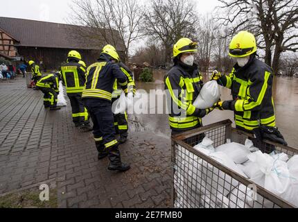 Lindheim, Deutschland. Januar 2021. Feuerwehrleute stapeln Sandsäcke, um Häuser vor der Überschwemmung des Nidder zu schützen. In der Wetterau haben zahlreiche Flüsse ihre Ufer durch den schmelzenden Schnee und die anhaltenden Niederschläge geplatzt. Quelle: Boris Roessler/dpa/Alamy Live News Stockfoto