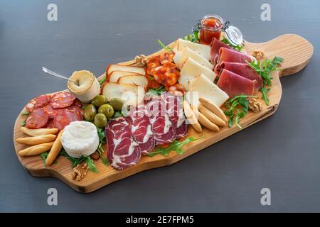 Sehr farbenfrohe Tapas-Tafel mit Wurstwaren und Käse. Dekoriert mit Rucola und Walnüssen. Stockfoto