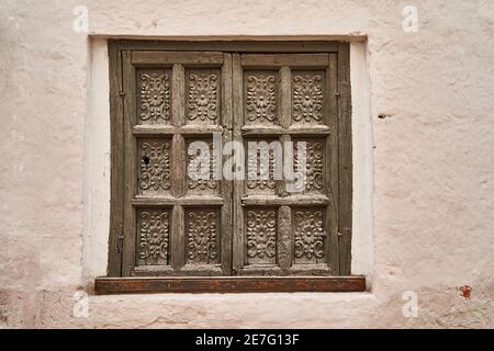 Antik aussehende Fensterläden aus Holz mit Holzschnitzereien und Ornamenten Im mediterranen Stil wie in Italien oder Spanien Stockfoto