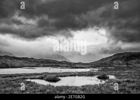 Episches Schwarz-Weiß-Landschaftsbild von Loch Ba auf Rannoch Moor in den schottischen Highlands an einem Wintermorgen Stockfoto