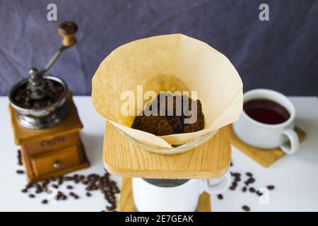 Eine selektive Fokusaufnahme von gemahlenen Kaffeebohnen, die in enthalten sind Ein Filterpapier mit Tropftröpfer Stockfoto