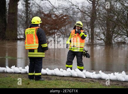 Lindheim, Deutschland. Januar 2021. Feuerwehrleute stapeln Sandsäcke, um Häuser vor der Überschwemmung des Nidder zu schützen. In der Wetterau haben zahlreiche Flüsse ihre Ufer durch den schmelzenden Schnee und die anhaltenden Niederschläge geplatzt. Quelle: Boris Roessler/dpa/Alamy Live News Stockfoto