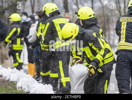 Lindheim, Deutschland. Januar 2021. Feuerwehrleute stapeln Sandsäcke, um Häuser vor der Überschwemmung des Nidder zu schützen. In der Wetterau haben zahlreiche Flüsse ihre Ufer durch den schmelzenden Schnee und die anhaltenden Niederschläge geplatzt. Quelle: Boris Roessler/dpa/Alamy Live News Stockfoto