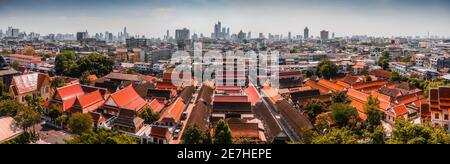 Panoramablick auf die traditionelle thailändische Architektur mit modernen Gebäuden und Wolkenkratzern im Hintergrund. Stadtbild von Bangkok, Thailand von Templ aus gesehen Stockfoto