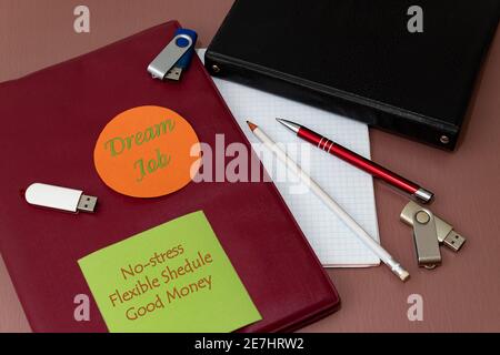 Traumjob, stressfrei, flexibler Zeitplan, gutes Geld. Text auf farbigen Aufklebern auf einem Notizbuch am Arbeitsplatz. Stockfoto