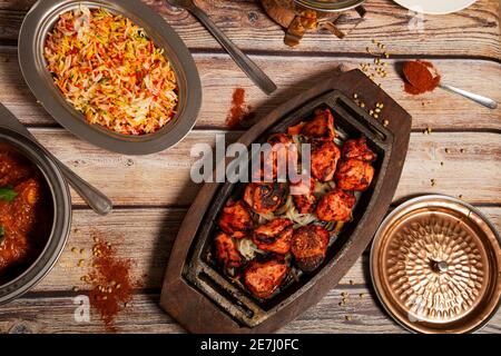 Auswahl an indischen Currygerichten mit Tandoori-Hühnchen und Basmati-Reis. Stockfoto