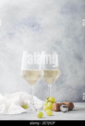 Gläser von weißen hausgemachten Sommer erfrischenden Wein mit Korken und Trauben auf hellem Stein Hintergrund. Stockfoto