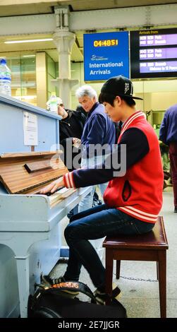 LONDON, ENGLAND, Großbritannien - 2. MAI 2014: Junger Mann spielt Klavier in der Nähe des Eurostar-Ankunftsgates am St. Pancras International Station. Street Pianos Project Stockfoto