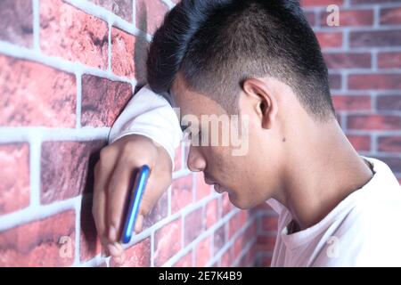 Nahaufnahme eines traurigen Mannes, der das Gesicht mit der Hand bedeckt. Stockfoto