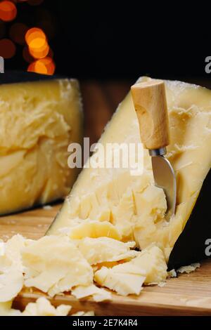 Mittlerer Hartkäse-Kopf Parmesan auf Holzbrett, mit Käse-Parmesan Messer. Stockfoto