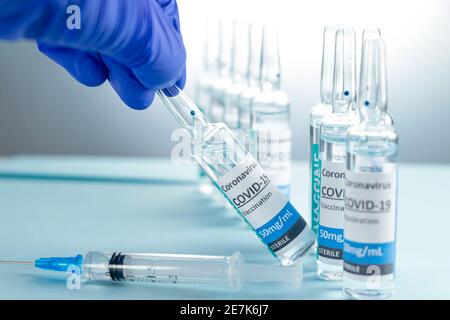 Arzt, Krankenschwester, Wissenschaftler, Forscher Hand in blauen Handschuhen mit Coronavirus, covid-19-Impfstoff-Krankheit Vorbereitung für menschliche klinische Studien Impfung Stockfoto