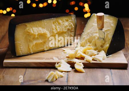 Mittlerer Hartkäse-Kopf Parmesan auf Holzbrett, mit Käse-Parmesan Messer. Stockfoto