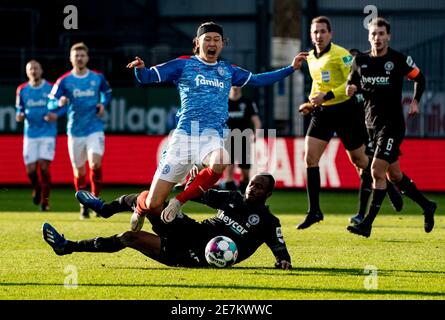 Kiel, Deutschland. Januar 2021. Fußball: 2. Bundesliga, Holstein Kiel - Eintracht Braunschweig, Matchday 19. Kiels Jae Sung Lee (oben) und Braunschweigs Oumar Diakhite kämpfen um den Ball. Quelle: Axel Heimken/dpa - WICHTIGER HINWEIS: Gemäß den Bestimmungen der DFL Deutsche Fußball Liga und/oder des DFB Deutscher Fußball-Bund ist es untersagt, im Stadion und/oder des Spiels aufgenommene Fotos in Form von Sequenzbildern und/oder videoähnlichen Fotoserien zu verwenden oder zu verwenden./dpa/Alamy Live News Stockfoto