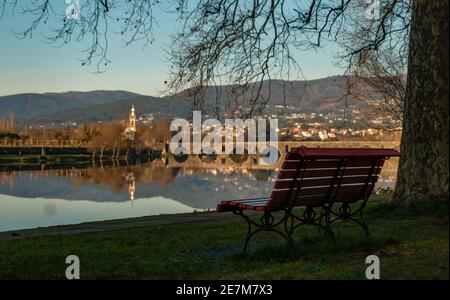 Ein Bild von einer Bank in der Stadt Ponte de Lima und der ikonischen Lima-Brücke (oder Ponte de Lima, wie die Brücke gab den Namen der Stadt als auch). Stockfoto