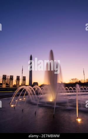 Der Himmel leuchtet lila im Licht der Morgenröte am World war II Memorial in der National Mall in Washington, DC. Stockfoto