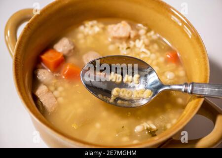 Ein Löffel Hühnchen Nudel Alphabet Suppe buchstabiert aus "HAUSGEMACHTEN". Studio auf weiß eingerichtet. Stockfoto