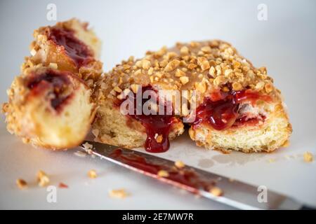 Studioaufnahme einer Erdnussbutter und einem Gelee-Donut mit aussickender Gelee. Stockfoto