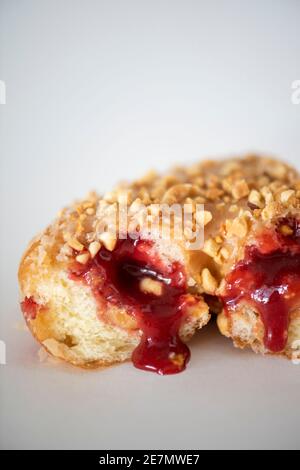 Studioaufnahme einer Erdnussbutter und einem Gelee-Donut mit aussickender Gelee. Stockfoto