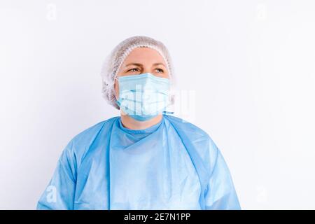 Porträt einer älteren Ärztin in Schutzausrüstung vor weißem Hintergrund mit seitlichem Leerraum. Stockfoto