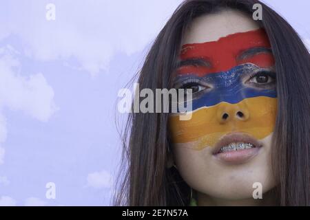 Flagge Armeniens auf dem Gesicht eines Jungen gemalt Weiblich Stockfoto