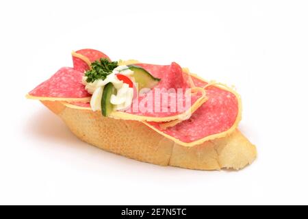 Traditionelle tschechische Snack namens chlebicek. Salami- und Gurkenscheiben mit Mayonnaise dekorativ auf kleines, weiches Weißbrot gelegt. Stockfoto