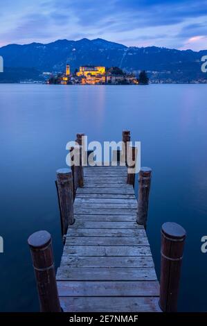 Sonnenuntergang in der Nähe einer Anlegestelle vor der Insel San Giulio und dem Ortasee. Orta San Giulio, See Orta, Provinz Novara, Piemont, Italien. Stockfoto