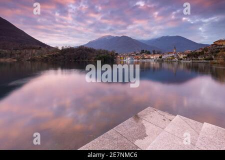 Blick auf die kleine Stadt Mergozzo und den See Mergozzo bei einem Winteruntergang. Verbano Cusio Ossola, Piemont, Italien. Stockfoto