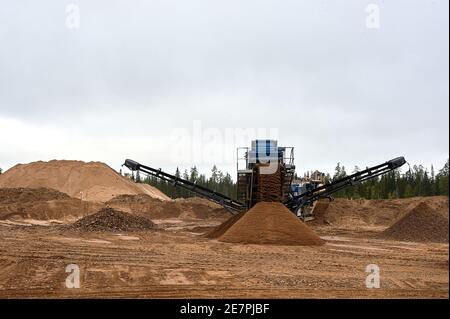 Mechanische Maschine zum Zerkleinern von Steinen mit Sand. Steinbruch für die Gewinnung von Schotter, Sand und Kies Stockfoto