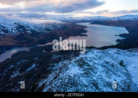 Ben A'an und Loch Katrine, Loch Lomond und Trossachs National Park, Schottland, Großbritannien. Januar 2021. Im Bild: Auf Schottlands Berggipfeln bleiben eisige Temperaturen mit dem leeren Gipfel des Ben A'an während der Phase-4-Sperre und Schnee bedeckt seinen Gipfel noch immer mit der Kulisse von Loch Katrine und den umliegenden Bergen des Nationalparks in der Ferne. Mehr Eis und Schnee werden prognostiziert. Quelle: Colin Fisher/Alamy Live News Stockfoto