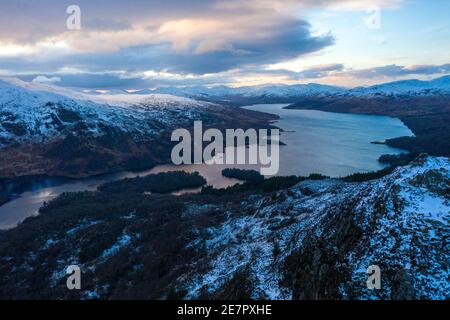 Ben A'an und Loch Katrine, Loch Lomond und Trossachs National Park, Schottland, Großbritannien. Januar 2021. Im Bild: Auf Schottlands Berggipfeln bleiben eisige Temperaturen mit dem leeren Gipfel des Ben A'an während der Phase-4-Sperre und Schnee bedeckt seinen Gipfel noch immer mit der Kulisse von Loch Katrine und den umliegenden Bergen des Nationalparks in der Ferne. Mehr Eis und Schnee werden prognostiziert. Quelle: Colin Fisher/Alamy Live News Stockfoto