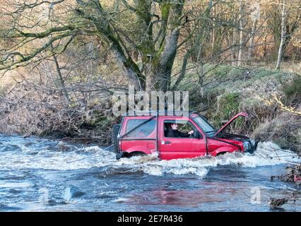 **BITTE BEACHTEN SIE DAS KORREKTE DATUM** River Rescue West Lothian, Schottland, UK. Januar 2021. Ein Mann holt sich ein Suzuki Jimny Fahrzeug mit Hund an Bord vom River Almond, West Lothian, Schottland. Quelle: Ian Rutherford/Alamy Live News. Stockfoto