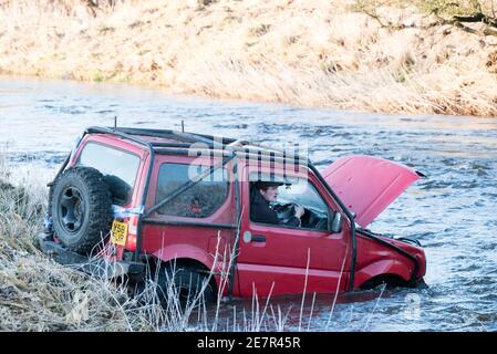 **BITTE BEACHTEN SIE DAS KORREKTE DATUM** River Rescue West Lothian, Schottland, UK. Januar 2021. Ein Mann holt sich ein Suzuki Jimny Fahrzeug mit Hund an Bord vom River Almond, West Lothian, Schottland. Quelle: Ian Rutherford/Alamy Live News. Stockfoto