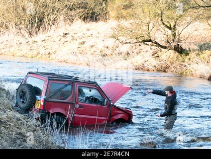 **BITTE BEACHTEN SIE DAS KORREKTE DATUM** River Rescue West Lothian, Schottland, UK. Januar 2021. Ein Mann holt sich ein Suzuki Jimny Fahrzeug mit Hund an Bord vom River Almond, West Lothian, Schottland. Quelle: Ian Rutherford/Alamy Live News. Stockfoto