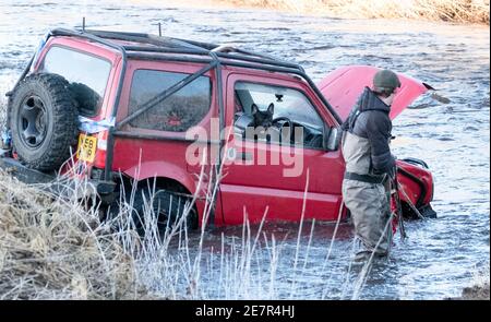 **BITTE BEACHTEN SIE DAS KORREKTE DATUM** River Rescue West Lothian, Schottland, UK. Januar 2021. Ein Mann holt sich ein Suzuki Jimny Fahrzeug mit Hund an Bord vom River Almond, West Lothian, Schottland. Quelle: Ian Rutherford/Alamy Live News. Stockfoto