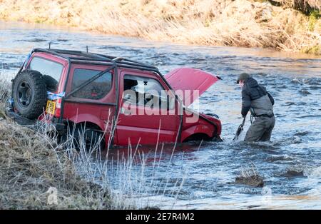 **BITTE BEACHTEN SIE DAS KORREKTE DATUM** River Rescue West Lothian, Schottland, UK. Januar 2021. Ein Mann holt sich ein Suzuki Jimny Fahrzeug mit Hund an Bord vom River Almond, West Lothian, Schottland. Quelle: Ian Rutherford/Alamy Live News. Stockfoto