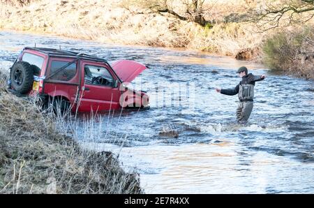 **BITTE BEACHTEN SIE DAS KORREKTE DATUM** River Rescue West Lothian, Schottland, UK. Januar 2021. Ein Mann holt sich ein Suzuki Jimny Fahrzeug mit Hund an Bord vom River Almond, West Lothian, Schottland. Quelle: Ian Rutherford/Alamy Live News. Stockfoto