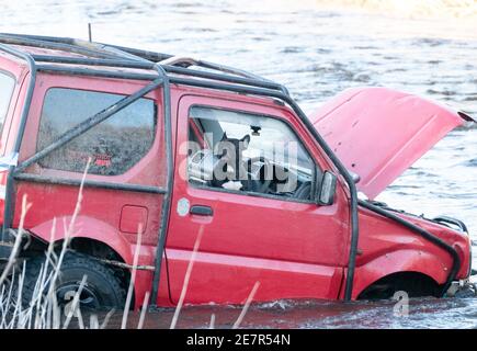 **BITTE BEACHTEN SIE DAS KORREKTE DATUM** River Rescue West Lothian, Schottland, UK. Januar 2021. Ein Mann holt sich ein Suzuki Jimny Fahrzeug mit Hund an Bord vom River Almond, West Lothian, Schottland. Quelle: Ian Rutherford/Alamy Live News. Stockfoto