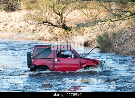 **BITTE BEACHTEN SIE DAS KORREKTE DATUM** River Rescue West Lothian, Schottland, UK. Januar 2021. Ein Mann holt sich ein Suzuki Jimny Fahrzeug mit Hund an Bord vom River Almond, West Lothian, Schottland. Quelle: Ian Rutherford/Alamy Live News. Stockfoto