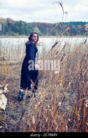 Brunette Frau in schwarzem Kleid ein See suchen erschrocken Stockfoto