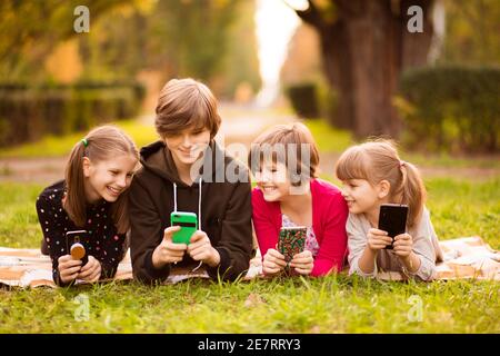 Gruppe von Freunden Mädchen mit Mobiltelefonen und chatten zusammen Im Park Stockfoto