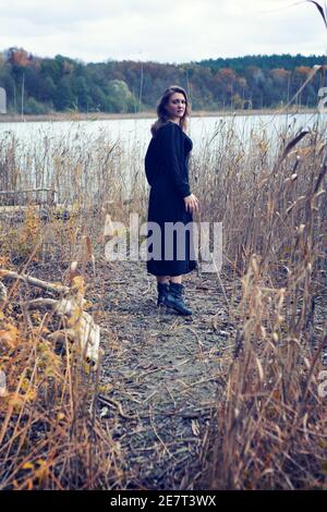 Brunette Frau in schwarzem Kleid ein See suchen erschrocken Stockfoto