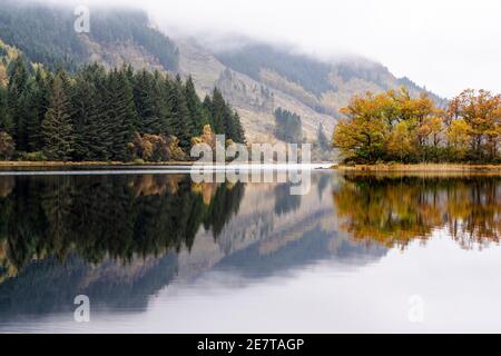 Herbstreflexionen über Loch Chon in den Trossachs, Schottland, Großbritannien Stockfoto