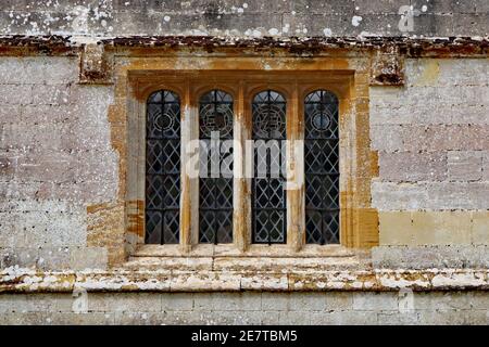 Ein altes Bleifenster mit einem Betonrahmen in einem Altes englisches Landhaus Stockfoto