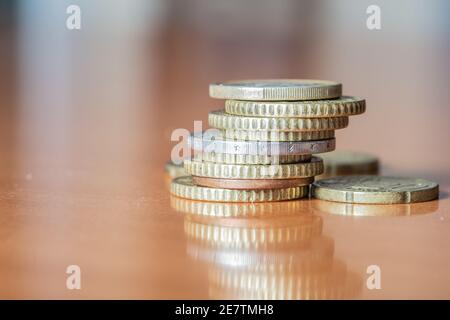 Nahaufnahme eines Anhäufs von Gold- und Bronzemünzen Auf Holzoberfläche Stockfoto