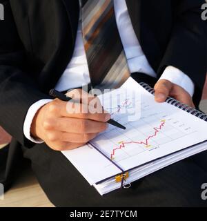 Businessman wertet Unternehmensdaten aus und prüft Diagramme und Werte Stockfoto