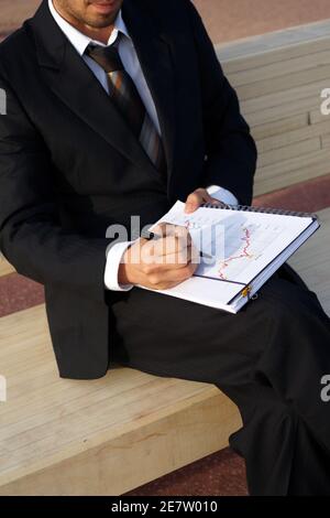 Businessman wertet Unternehmensdaten aus und prüft Diagramme und Werte Stockfoto