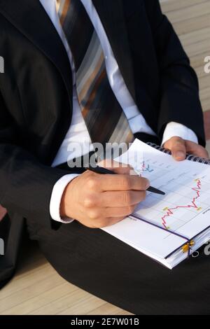 Businessman wertet Unternehmensdaten aus und prüft Diagramme und Werte Stockfoto