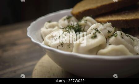 Hausgemachte Knödel, appetitliche Knödel auf einem Teller, russische Knödel, Ravioli. Hausgemachtes Essen. Stockfoto