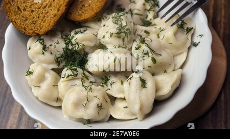 Hausgemachte Knödel, appetitliche Knödel auf einem Teller, russische Knödel, Ravioli. Hausgemachtes Essen. Stockfoto